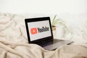 Laptop leżący na łóżku z logiem YouTube